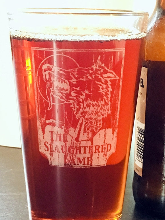 Wolf head sign of the slaughtered lamb sign on a beer glass